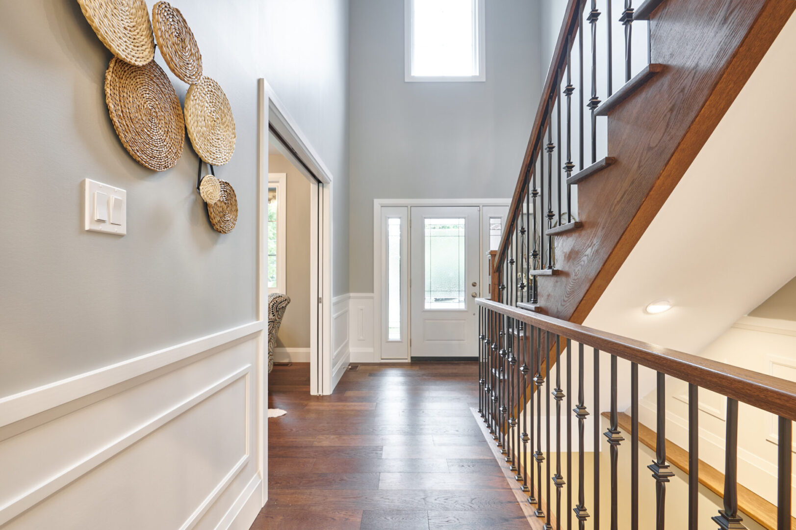 A hallway with a wooden floor and metal railing.
