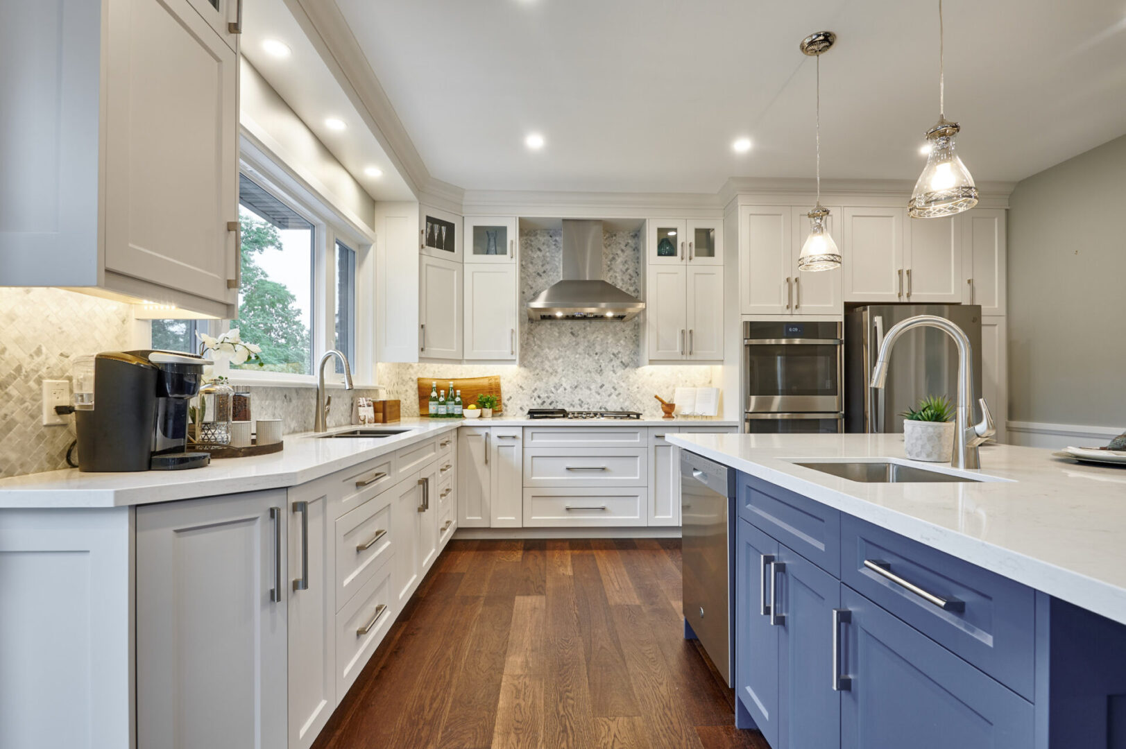 A kitchen with white cabinets and blue island.