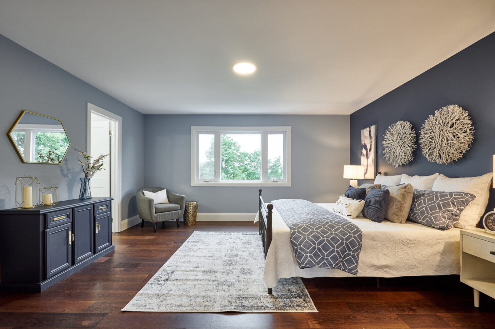A bedroom with hardwood floors and blue walls.